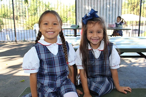 Two girls in Uniform at lunch table