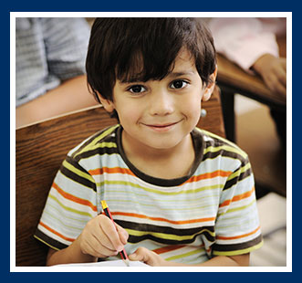 Boy sitting in his desk writing