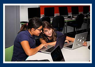 Female students use laptops in class